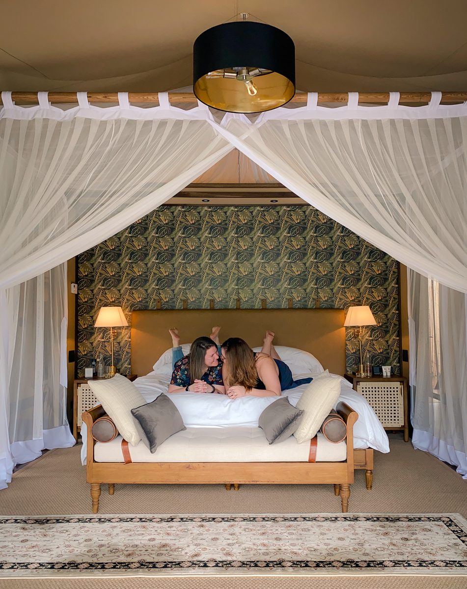 lesbian couple talking in bed at Nayara tented camp