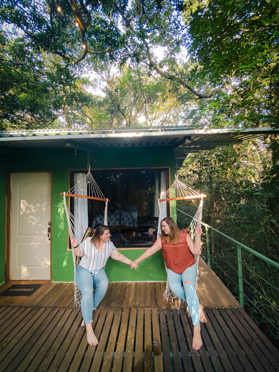 lesbian couple holding hands on porch swings