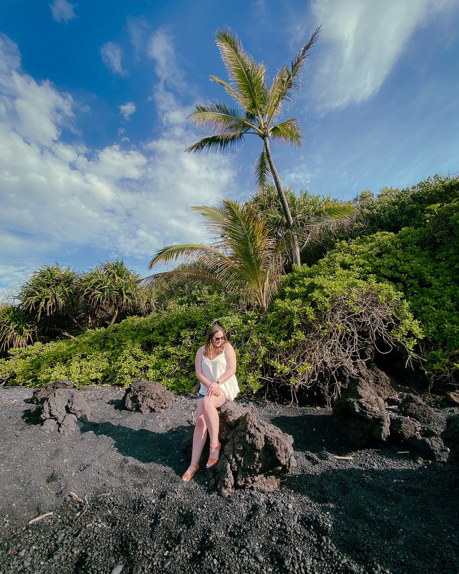 Woman on black sand beach in maui Hawaii