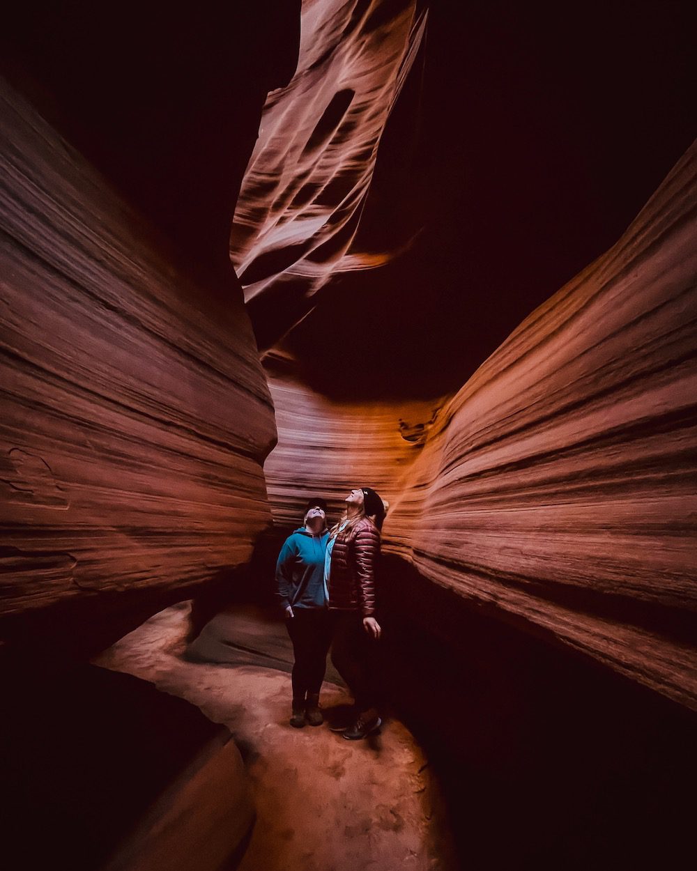 two women gazing in slot canyon